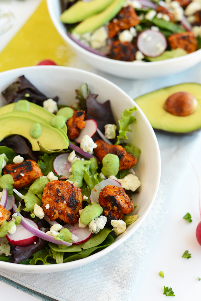 This Sriracha Chicken Salad is packed with veggies and blue cheese. It's topped with a homemade green goddess dressing that's made with a Greek yogurt base!