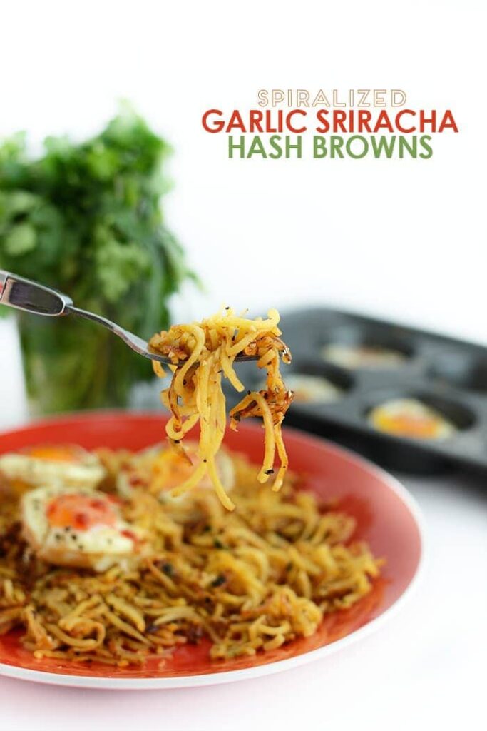 Got a yam? Make these paleo spiralized hash browns flavored with garlic and siriracha for a flavorful and filling breakfast paired with baked eggs!